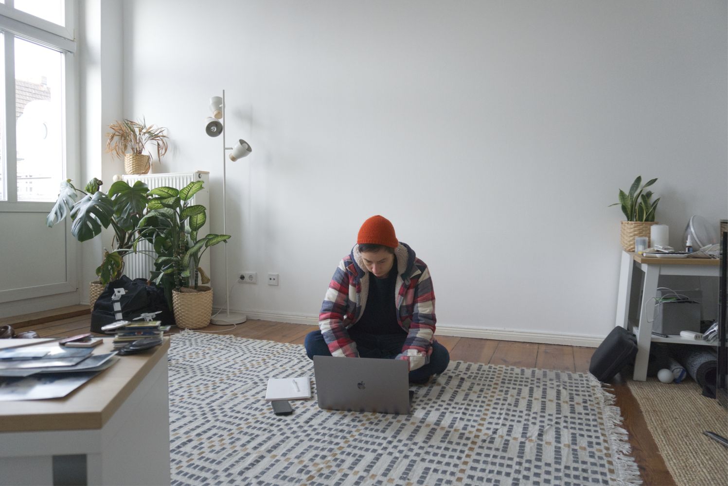 Sophie sitting on her laptop in her half-empty apartment