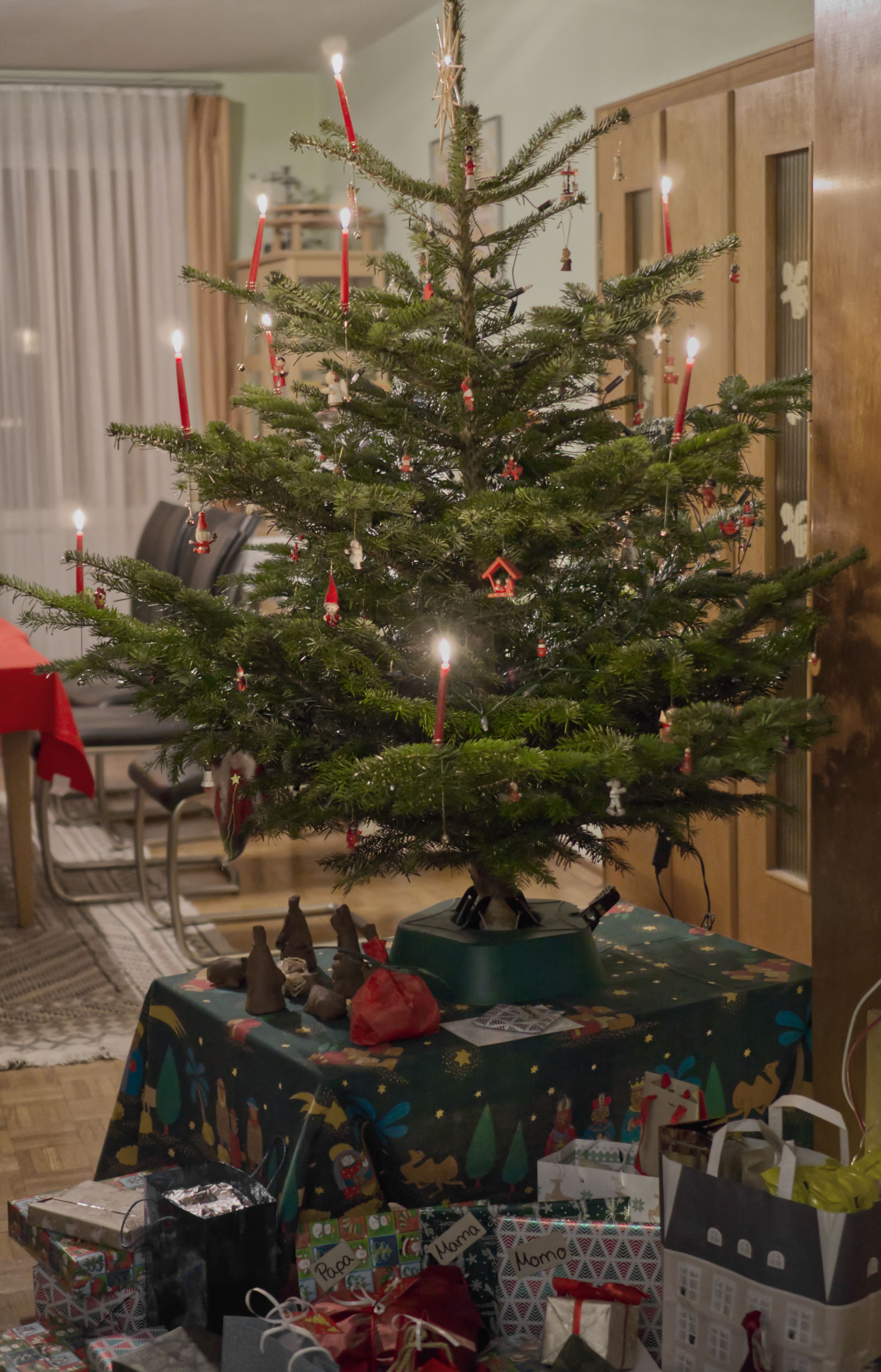 The Au family's fully decorated Christmas tree with lit candles